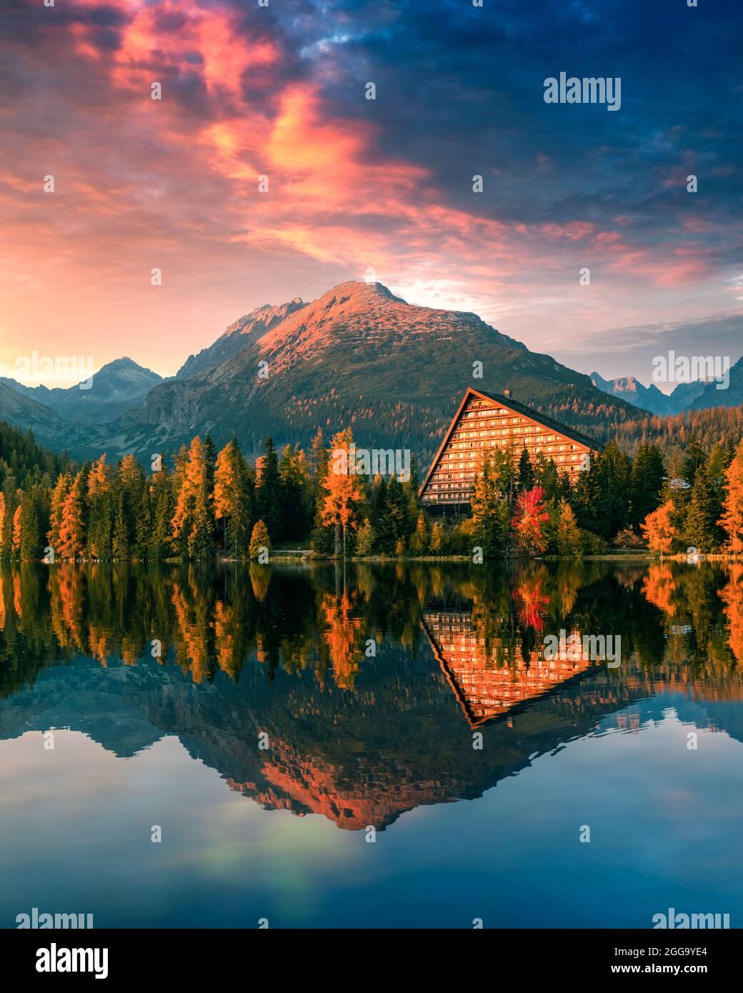 Malerische Herbstansicht des Strbske pleso Sees im Nationalpark hohe Tatra, Slowakei. Klares Wasser mit Reflexen von orangefarbener Lärche und hohen Bergen im Hintergrund. Landschaftsfotografie Stockfoto
