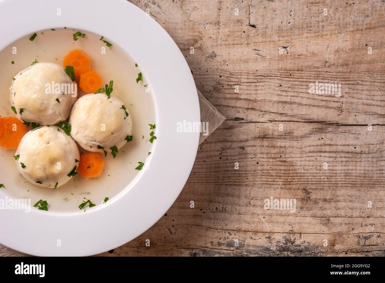 Traditionelle jüdische Matzah-Kugelsuppe auf Holztisch Stockfoto