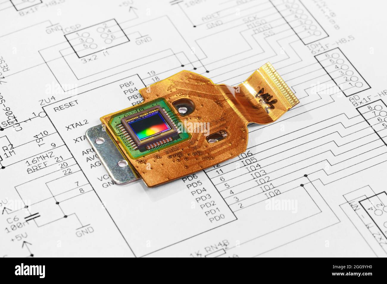 CMOS-Sensor auf flexibler Leiterplatte vor dem Hintergrund eines Schaltplans Stockfoto