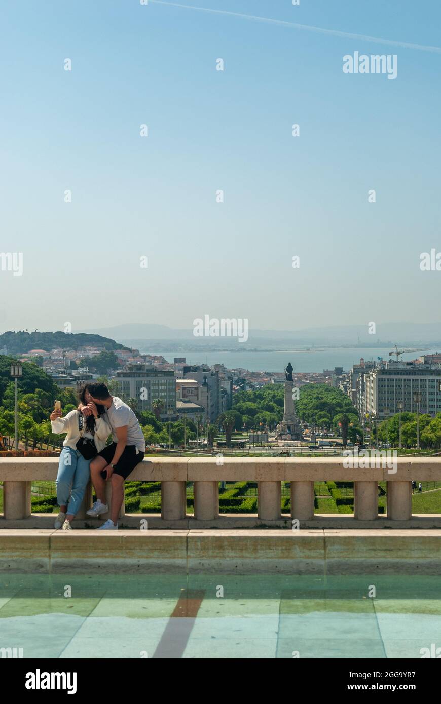 Lissabon, Portugal - 29. Mai 2021: Ein Paar, das sich vor dem Hintergrund der Stadt Lissabon küsst - Portugal, Vertikal, selektiver Fokus Stockfoto
