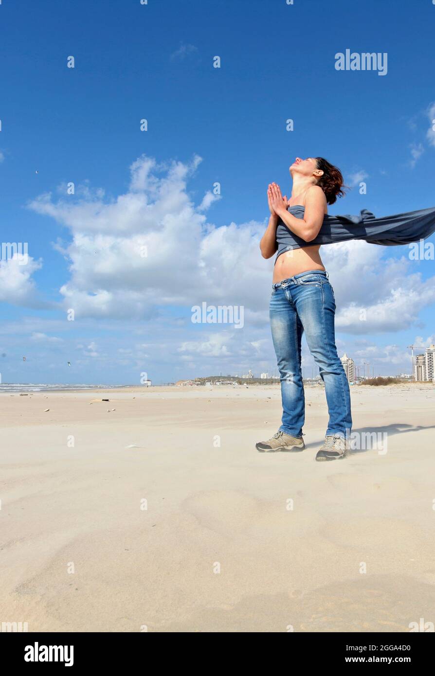 Spirituelle junge Frau kommuniziert mit den Geistern am Strand Stockfoto