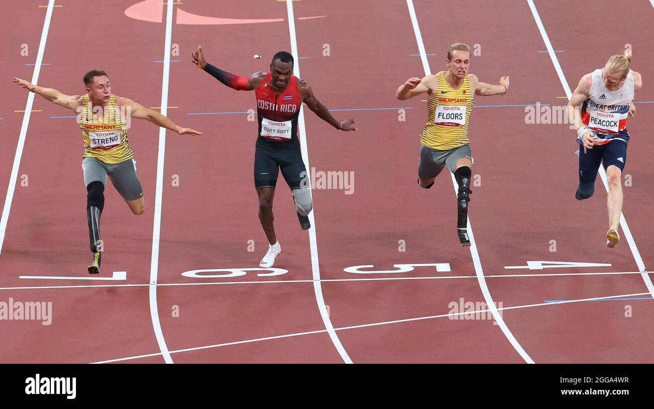 Tokio, Japan. August 2021. Paralympics: Leichtathletik, 100 m Männer, T64, Finale im Olympiastadion. Goldmedaillengewinnerin Felix streng (l-r) aus Deutschland, Sherman Isidro Guity Guity aus Costa Rica (silber) und die beiden Bronzemedaillengewinnerinnen Johannes Floors aus Deutschland und Jonnie Pfacock aus Großbritannien überqueren die Ziellinie. Quelle: Karl-Josef Hildenbrand/dpa/Alamy Live News Stockfoto