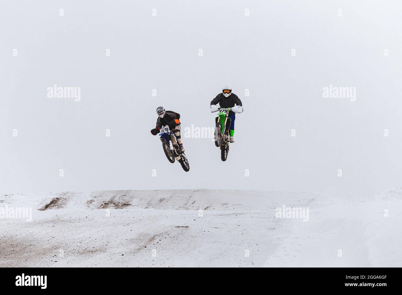 Zwei Motorrad-Rennfahrer springen schneebedeckten Hügel Rennen enudro Stockfoto