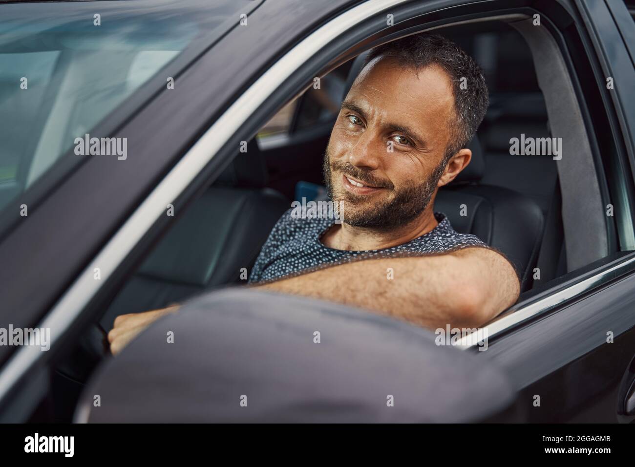 Selbstbewusster Fahrer lächelt vor einer weiteren Fahrt Stockfoto