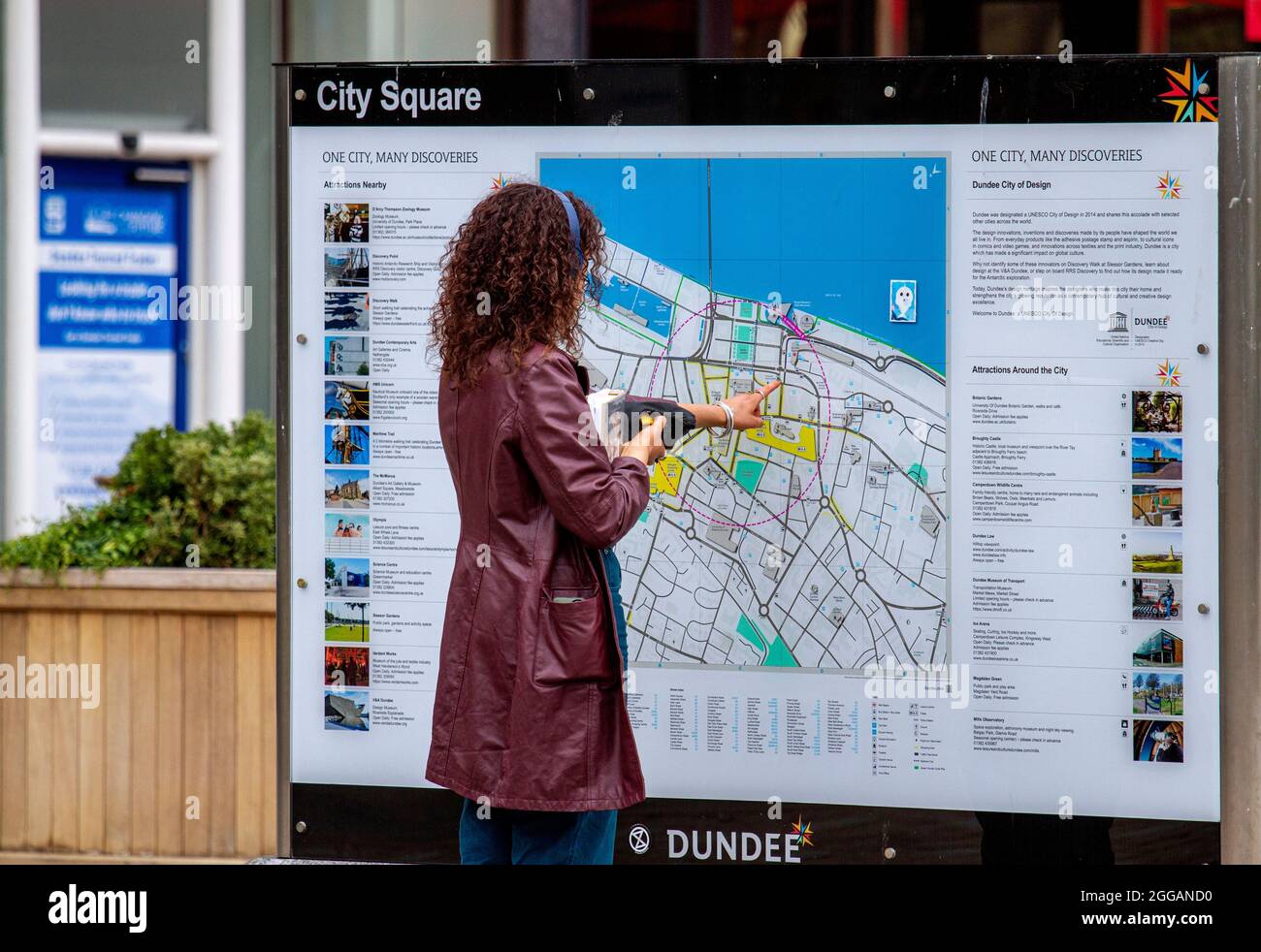 Dundee, Tayside, Schottland, Großbritannien. August 2021. Wetter in Großbritannien: Ein heller und warmer Tag in Nordostschottland mit Temperaturen von bis zu 18 Grad Der Feiertagsmontag zieht viele Einheimische an, um nach monatelangen Sperren des Coronavirus einen Tag mit Freunden im Freien zu verbringen. Eine sehr modische junge Frau, die sich einen Tag ausgibt, während sie die Touristeninformation studiert und nach einer Wegbeschreibung im Stadtzentrum von Dundee sucht. Kredit: Dundee Photographics/Alamy Live Nachrichten Stockfoto