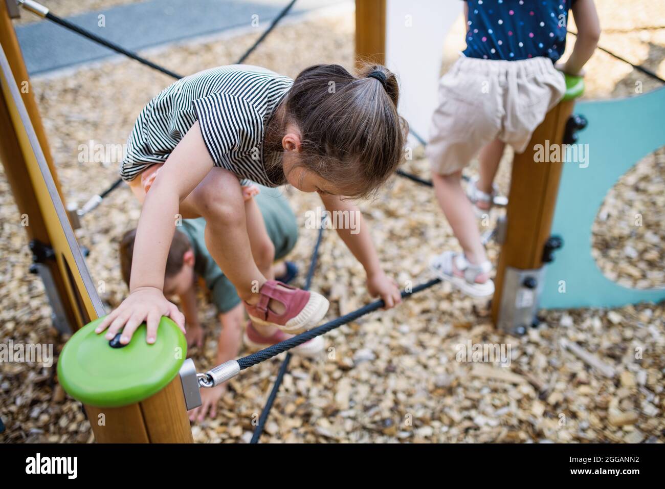 Gruppe von kleinen Kinderkrippen Kinder spielen im Freien auf dem Spielplatz, Klettern. Stockfoto