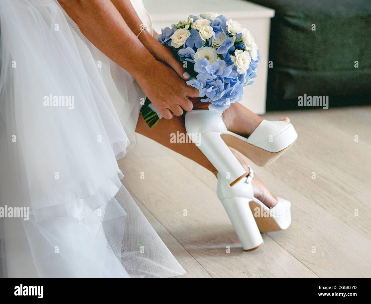 Braut mit Blumenstrauß in den Händen und weißen Sandalen Stockfoto
