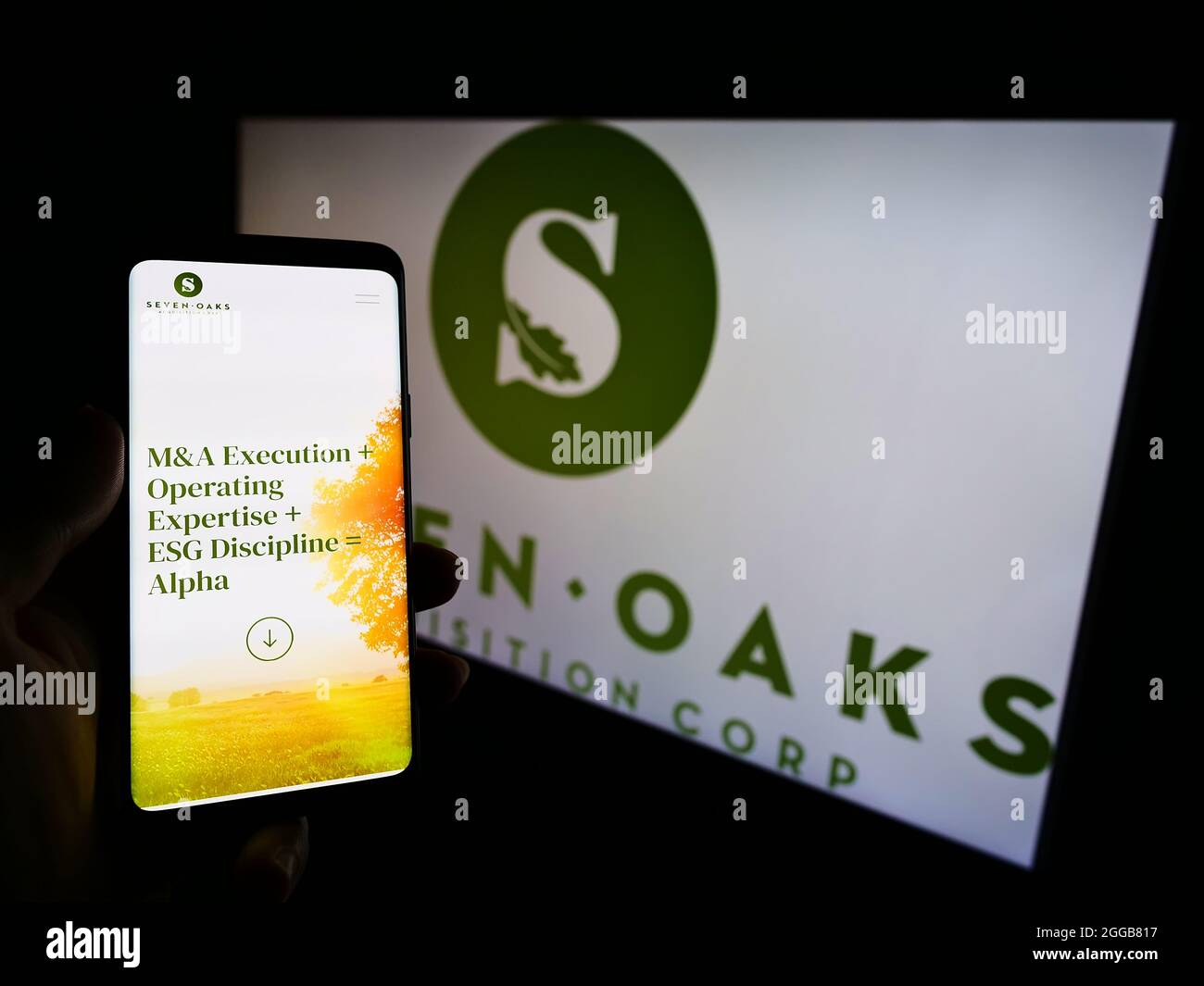 Person, die Mobiltelefon mit der Website des US-Unternehmens Seven Oaks Acquisition Corp. Auf dem Bildschirm vor dem Logo hält. Konzentrieren Sie sich auf die Mitte des Telefondisplays. Stockfoto