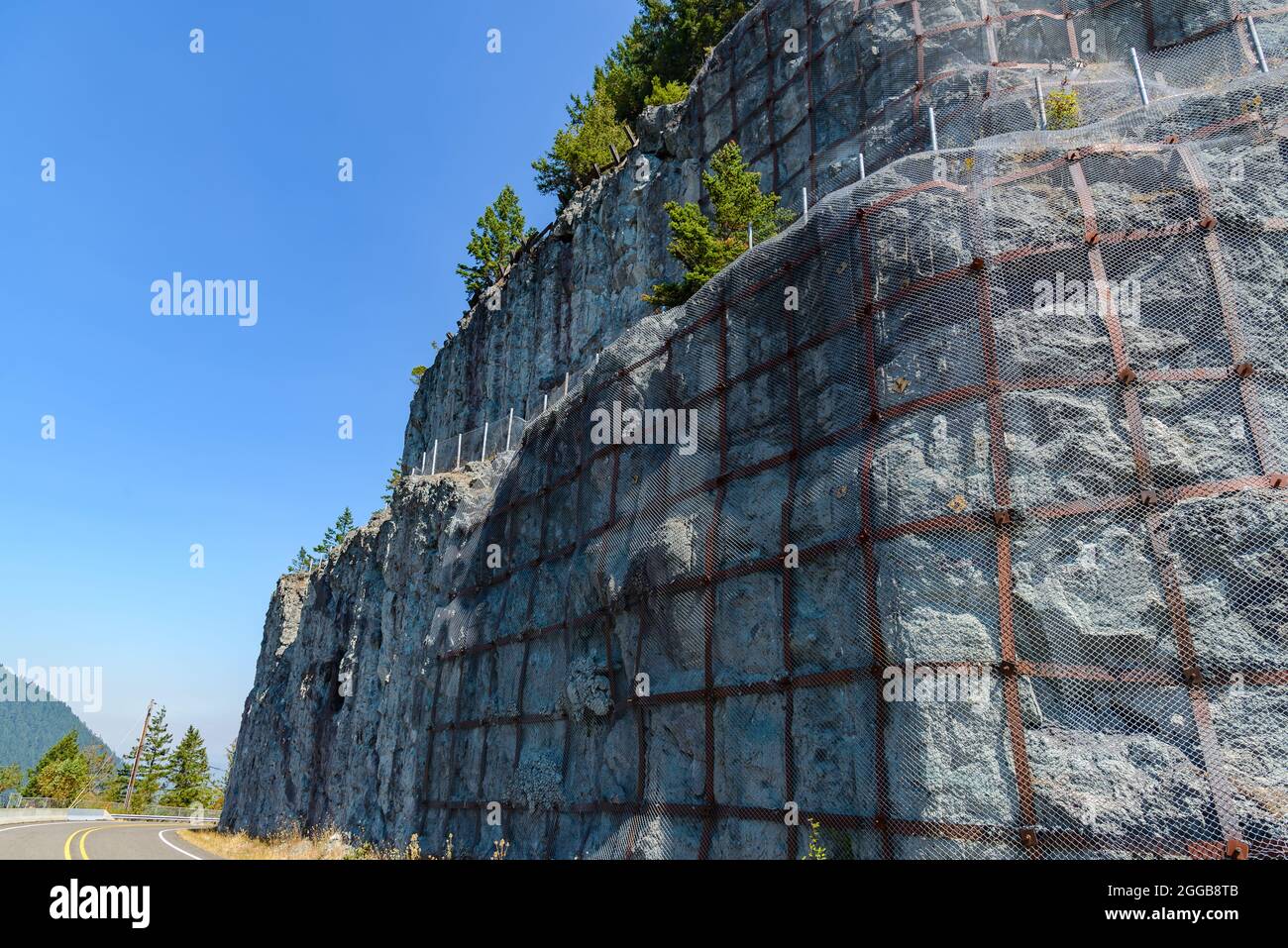 Metallgewebe bedeckt felsigen Hang, um fallende Felsen zu verhindern. Oregon, USA. Stockfoto