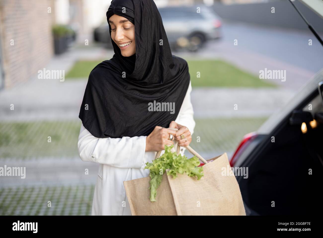 Muslimische Frau, die mit Lebensmitteln nach Hause kommt Stockfoto