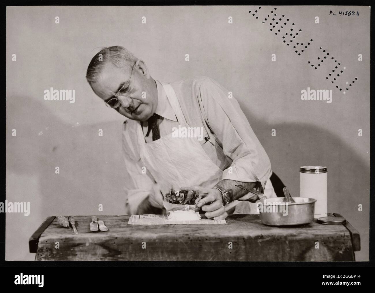 Frank Earl Holden demonstriert Cutting into Mineral, 18. Januar 1951. Frank E. Holden, Lapidarist und Museumstechniker in der Abteilung für Mineralogie und Petrologie, bereitet sich darauf vor, ein Zinnober aus der Provinz Hunan, China, zu schneiden. Stockfoto