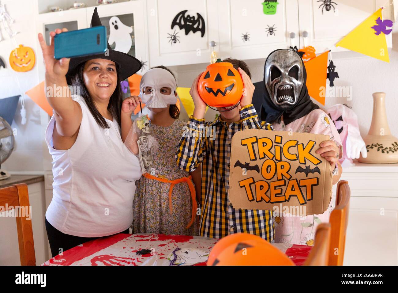 Familie zu Hause, die ein Foto mit dem Mobiltelefon gemacht hat, während sie die Halloween-Party feiert. Stockfoto