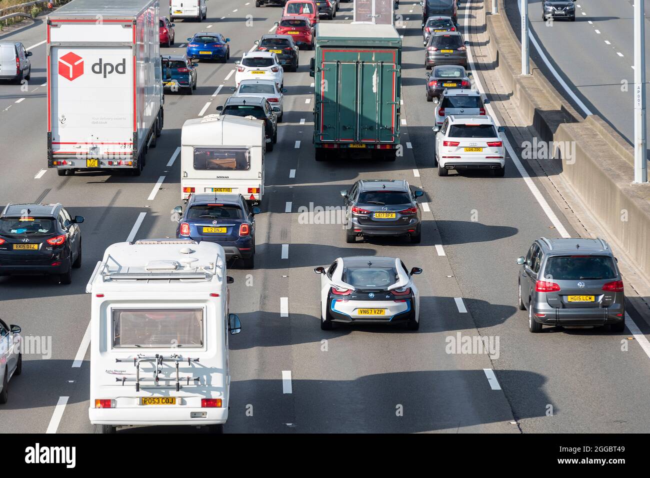 Abschnitt der Autobahn M25 in Longford in der Nähe des Flughafens Heathrow, Großbritannien, der an einem Sommerwochenende an den Feiertagen im August voll mit Verkehr ist. Wohnmobil und Wohnwagen Stockfoto