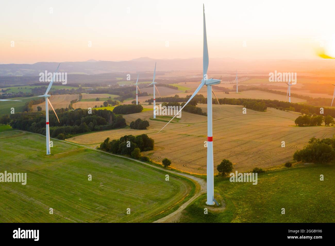 Luftaufnahme von Windenergieanlagen und Windmühlen im Feld. Alternative grüne elektrische Energieerzeugung. Stockfoto