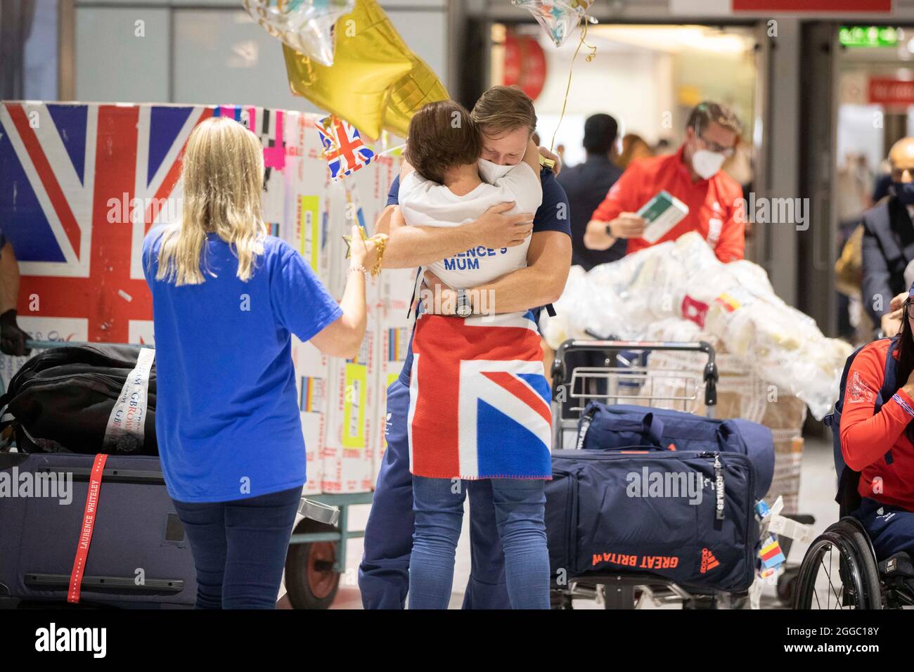 Goldmedaillengewinnerin Laurence Whiteley wird von seiner Mutter begrüßt, als er von den Paralympischen Spielen in Tokio 2020 am Flughafen London Heathrow ankommt. Bilddatum: Montag, 30. August 2021. Stockfoto