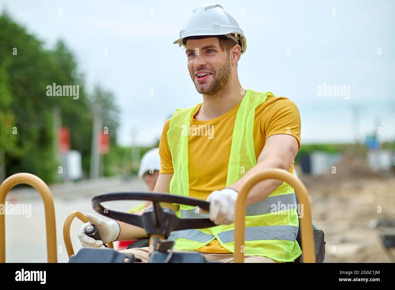 Hochbegabter Fahrer, der eine Erdstampfer-Maschine fährt Stockfoto