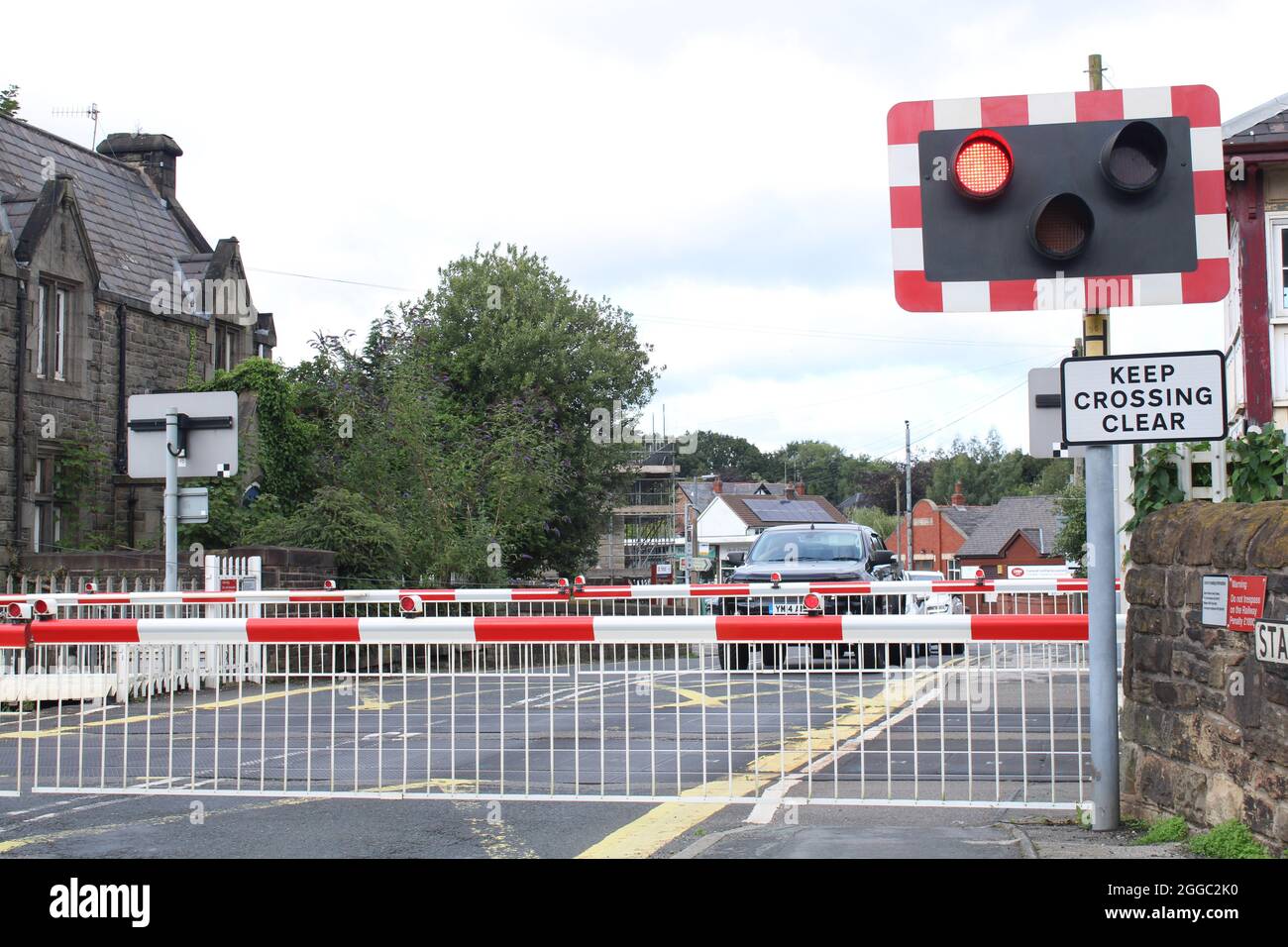 Die Bahnschwelle überquert eine Barriere, die Fahrzeuge warten, bis der Zug vorbeifährt. Parbold, Lancashire, Großbritannien Stockfoto