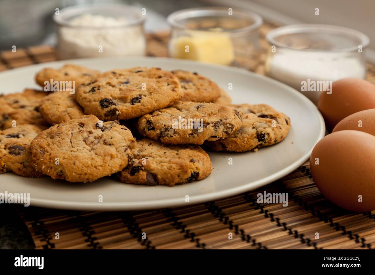 Nahaufnahme von hausgemachten Haferflocken-Keksen mit Schokolade und Zutaten im Hintergrund Stockfoto