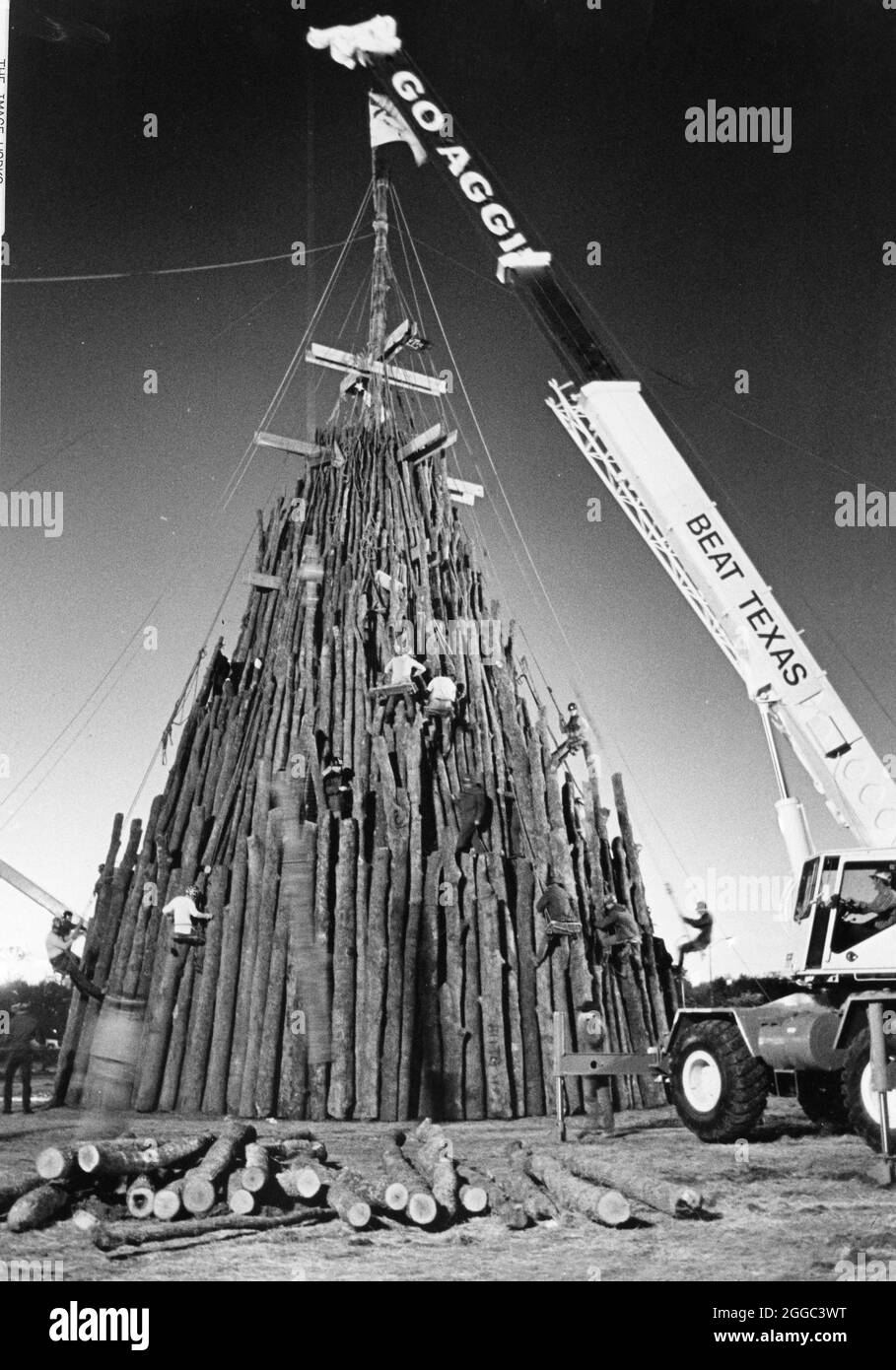 College Station Texas USA, 1978: Texas A&M Studenten verwenden einen Kran, um beim Bau des Texas A&M Aggie Bonfire Holzstapels vor dem jährlichen Texas vs. Texas A&M Football Spiel im späten Herbst zu helfen. ©Bob Daemmrich Stockfoto