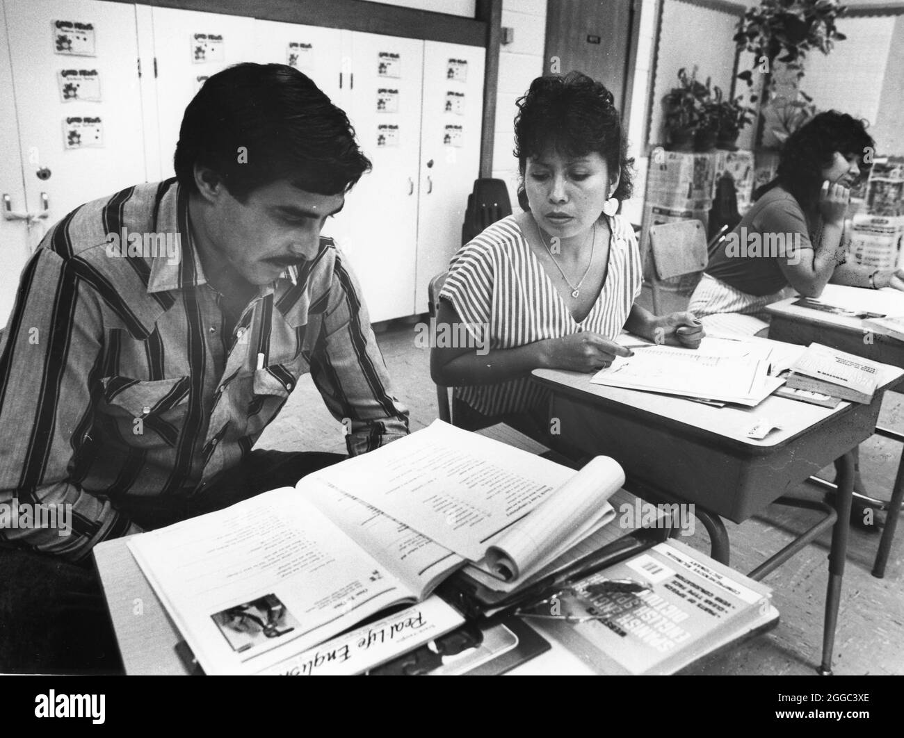 Austin Texas USA, 1989: Hispanische Einwanderer sehen sich das Arbeitsblatt während des Englischkurses im Gemeindezentrum an. ©Bob Daemmrich Stockfoto