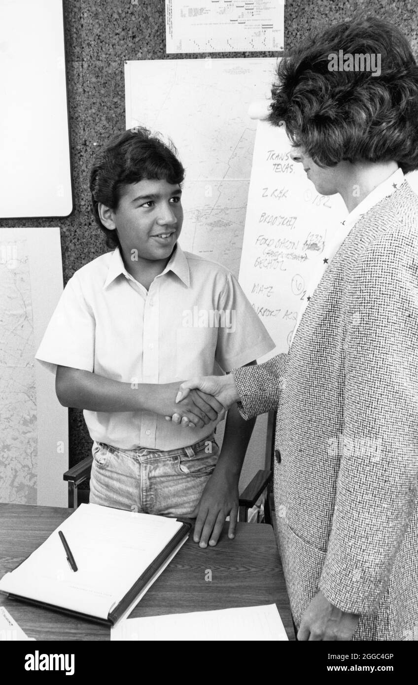 Austin Texas USA, 1993: Hispanic Teenager Interview für Sommerjob schüttelt Hand mit Human Resources Director. ©Bob Daemmrich Stockfoto