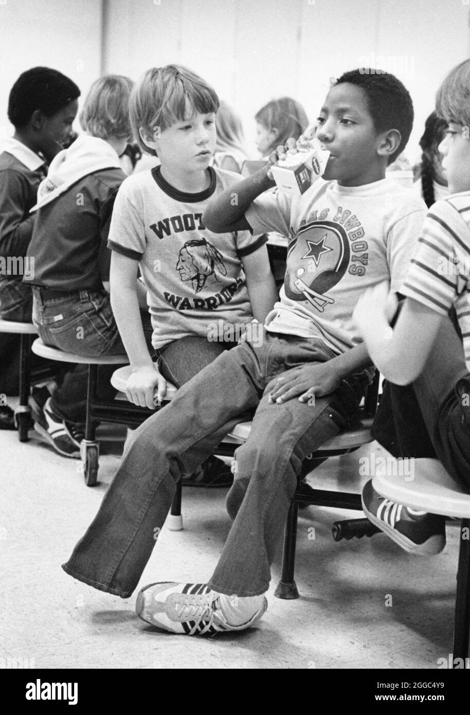 Austin Texas USA, 1984: Patrick Skeaton, der sein rechtes Bein wegen Spina bifida verlor, interagiert mit Klassenkameraden in der Schulcafeteria der Wooten Elementary. Später wurde er mit einer Beinprothese ausgestattet. Teil einer erweiterten Fotofunktion. ©Bob Daemmrich Stockfoto
