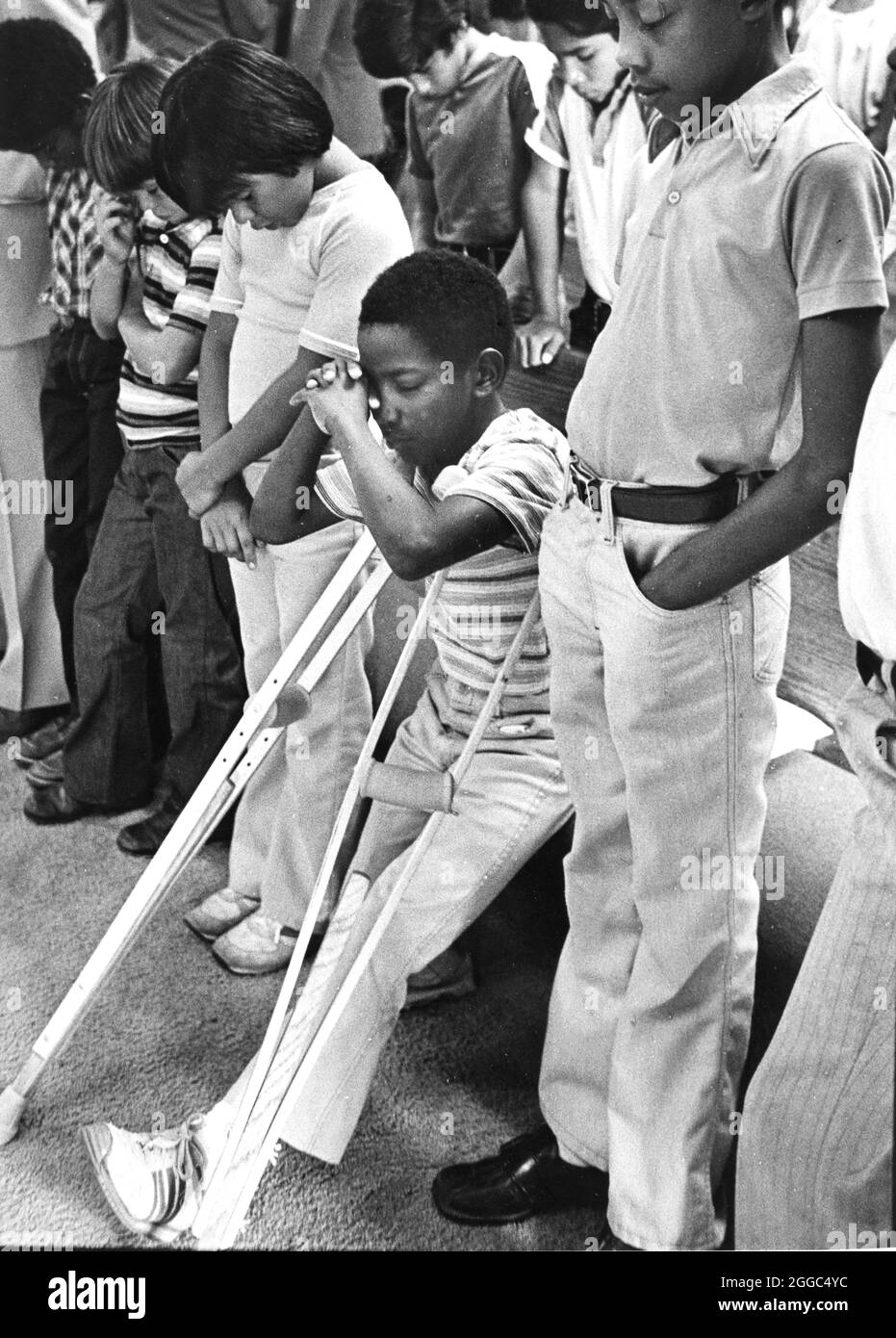 Austin Texas USA, 1984: Der schwarze Schüler Patrick Skeaton, der sein rechtes Bein aufgrund einer Spina bifida verlor, benutzt Holzkrücken, um an der Wooten Elementary School in Austin, Texas, zu kommen, während er in den regulären Unterricht integriert wird. Später wurde er mit einer Beinprothese ausgestattet. Teil einer erweiterten Fotofunktion. ©Bob Daemmrich Stockfoto