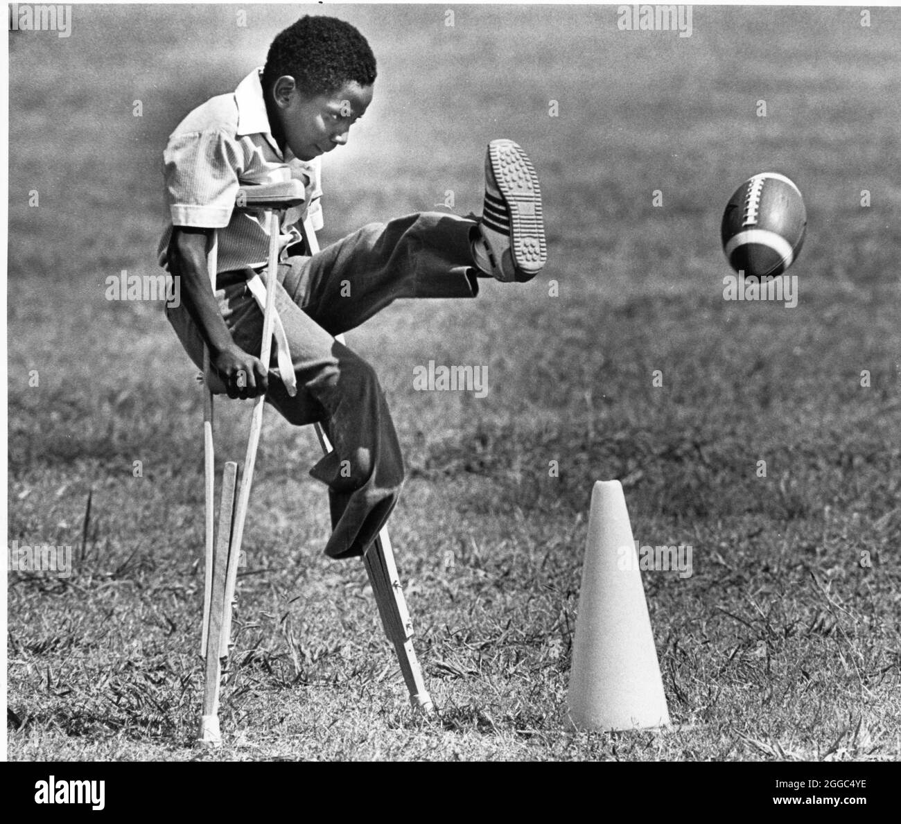 Austin Texas USA, 1984: Der schwarze Schüler Patrick Skeaton, der sein rechtes Bein aufgrund einer Spina bifida verlor, benutzt Holzkrücken, um an der Wooten Elementary School in Austin, Texas, zu kommen, während er in den regulären Unterricht integriert wird. Später wurde er mit einer Beinprothese ausgestattet. Teil einer erweiterten Fotofunktion. ©Bob Daemmrich Stockfoto