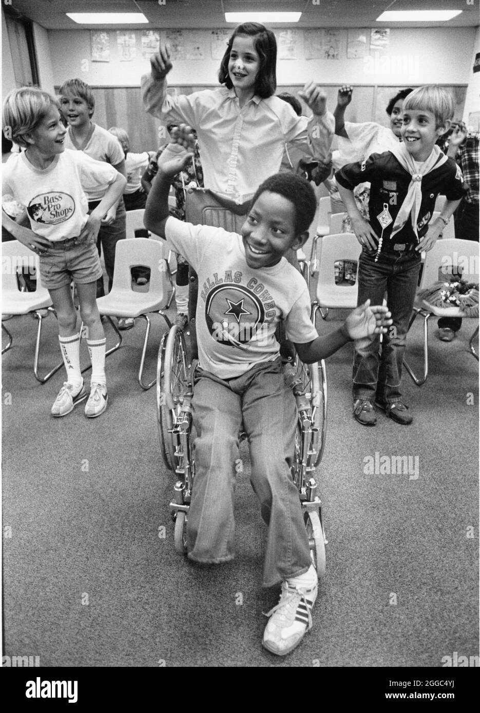 Austin Texas USA, 1984: Der schwarze Schüler Patrick Skeaton, der sein rechtes Bein aufgrund einer Spina bifida verlor, interagiert mit Klassenkameraden der Wooten Elementary School, während er in den regulären Unterricht einbezogen wird. Später wurde er mit einer Beinprothese ausgestattet. Teil einer erweiterten Fotofunktion. ©Bob Daemmrich Stockfoto