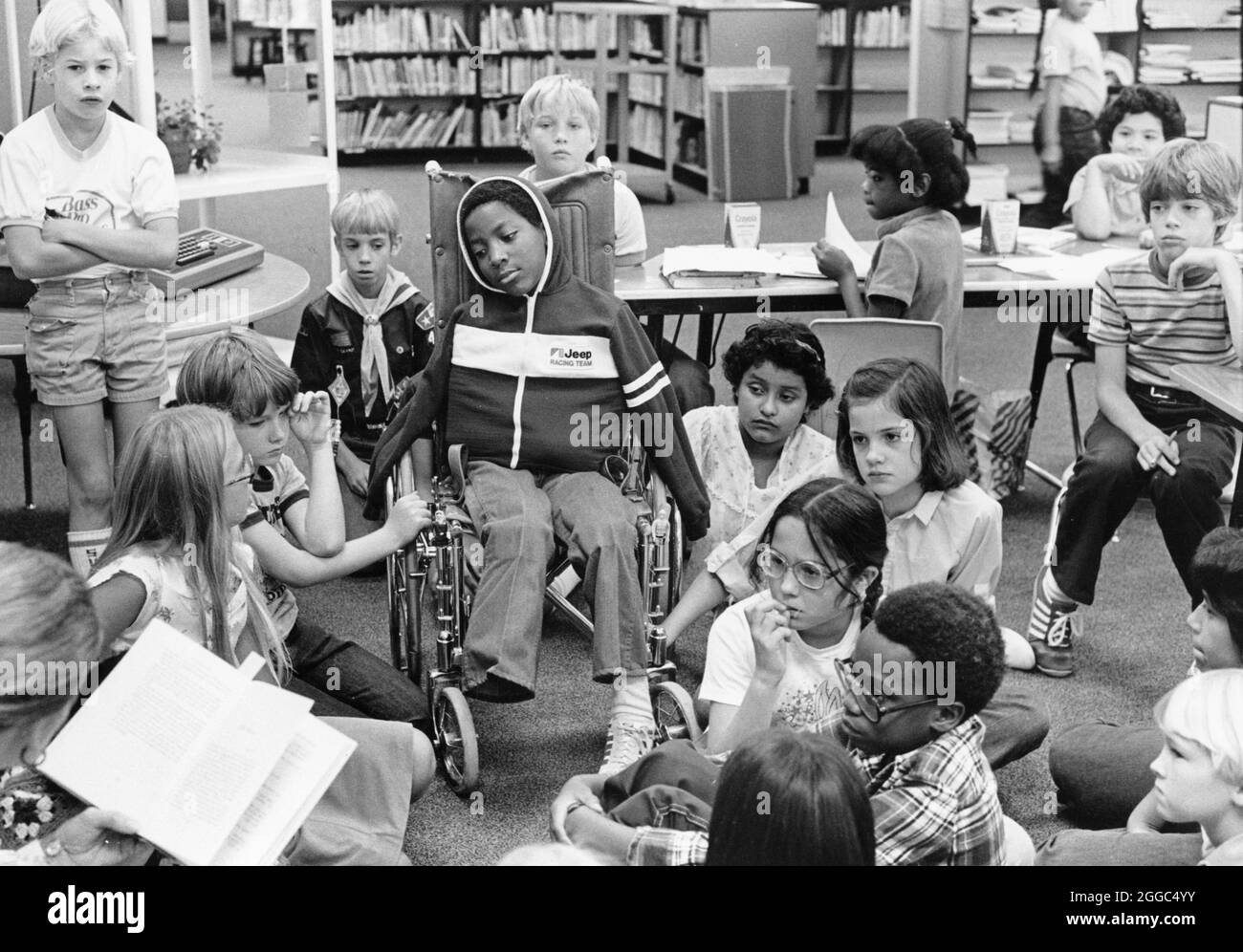 Austin Texas USA, 1984: Der schwarze Schüler Patrick Skeaton, der sein rechtes Bein aufgrund einer Spina bifida verlor, interagiert an der Wooten Elementary School, während er in den regulären Unterricht aufgenommen wird. Später wurde er mit einer Beinprothese ausgestattet. Teil einer erweiterten Fotofunktion. ©Bob Daemmrich Stockfoto