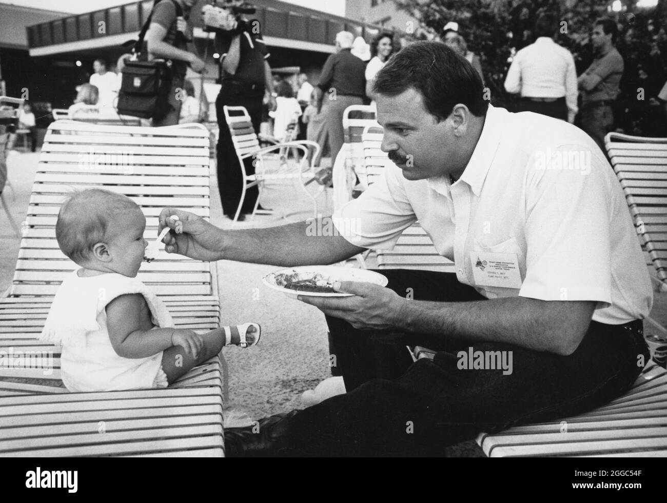 ©1980 Vater füttert Baby mit Plastiklöffel während der Weihnachtsfeier für Polizisten. ©Bob Daemmrich Stockfoto