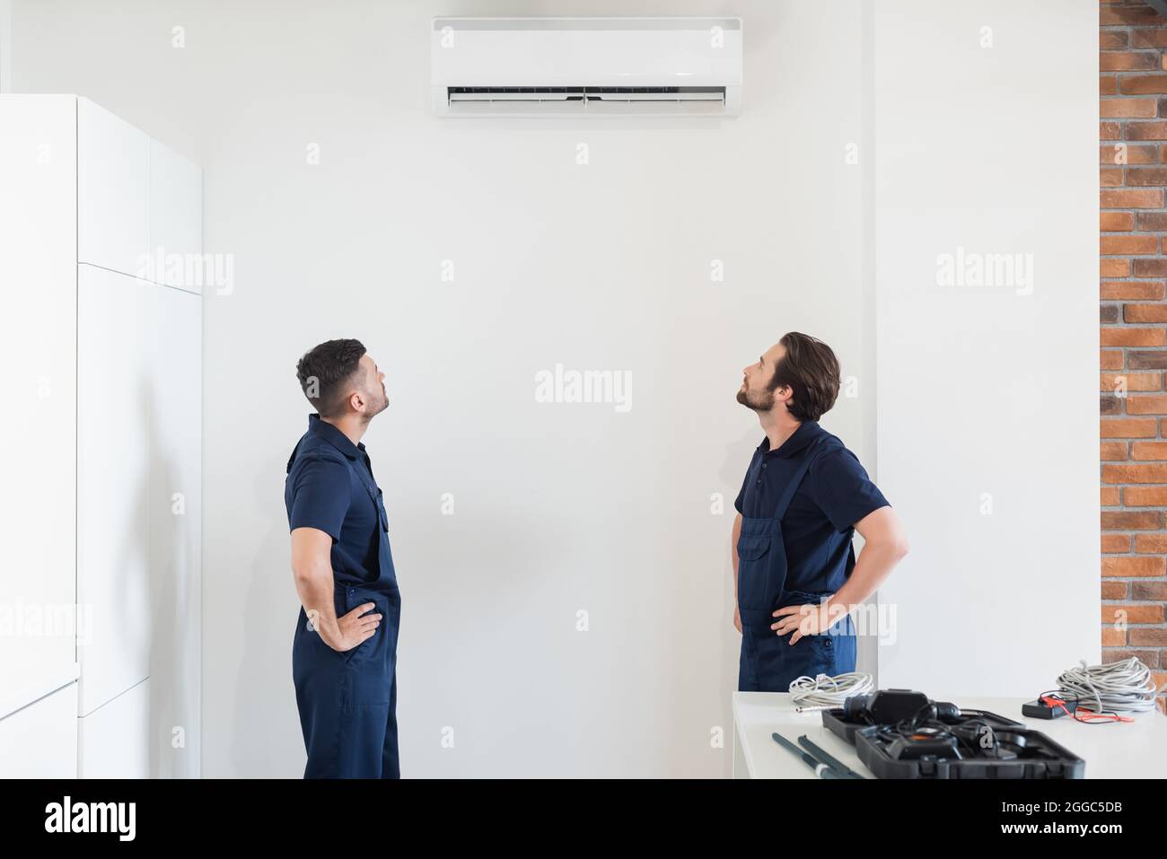Die Reparaturleute schauten sich die Klimaanlage an der weißen Wand in der  Küche an Stockfotografie - Alamy