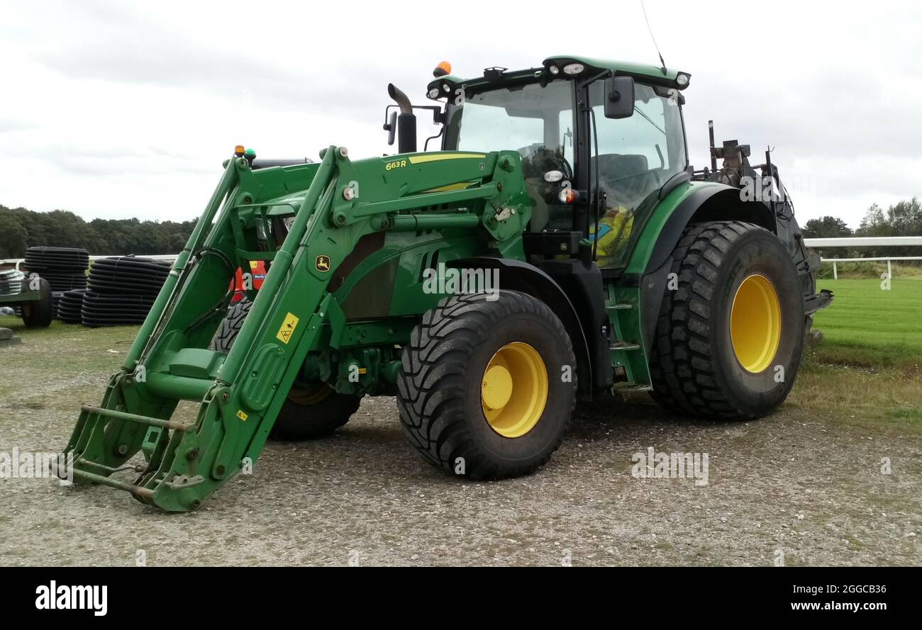 Ein grüner Traktor der Serie 6 von John Deere mit einem Frontlader 663R, der in Exeter, Devon, England, geparkt ist. Stockfoto