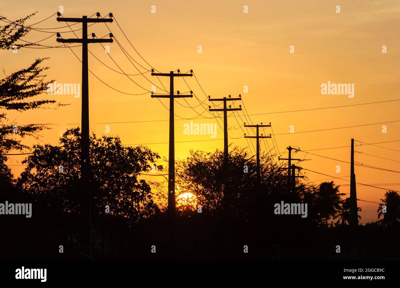 Elektrisierende Beiträge mit orangefarbenem Sonnenuntergang Himmel Hintergrund. Stockfoto