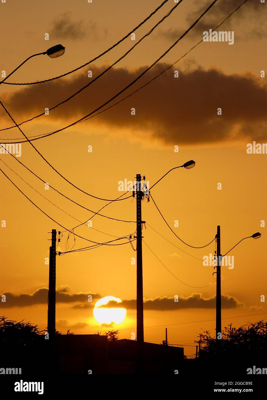 Elektrisierende Beiträge mit orangefarbenem Sonnenuntergang Himmel Hintergrund. Stockfoto