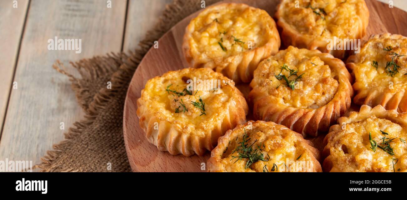 Heiße leckere Muffins mit Gemüse und Käse auf einem Holzbrett. Rezept für ein herbstlich saisonales Gericht. Köstliche hausgemachte Kuchen für eine gesunde Ernährung. Banner für Stockfoto