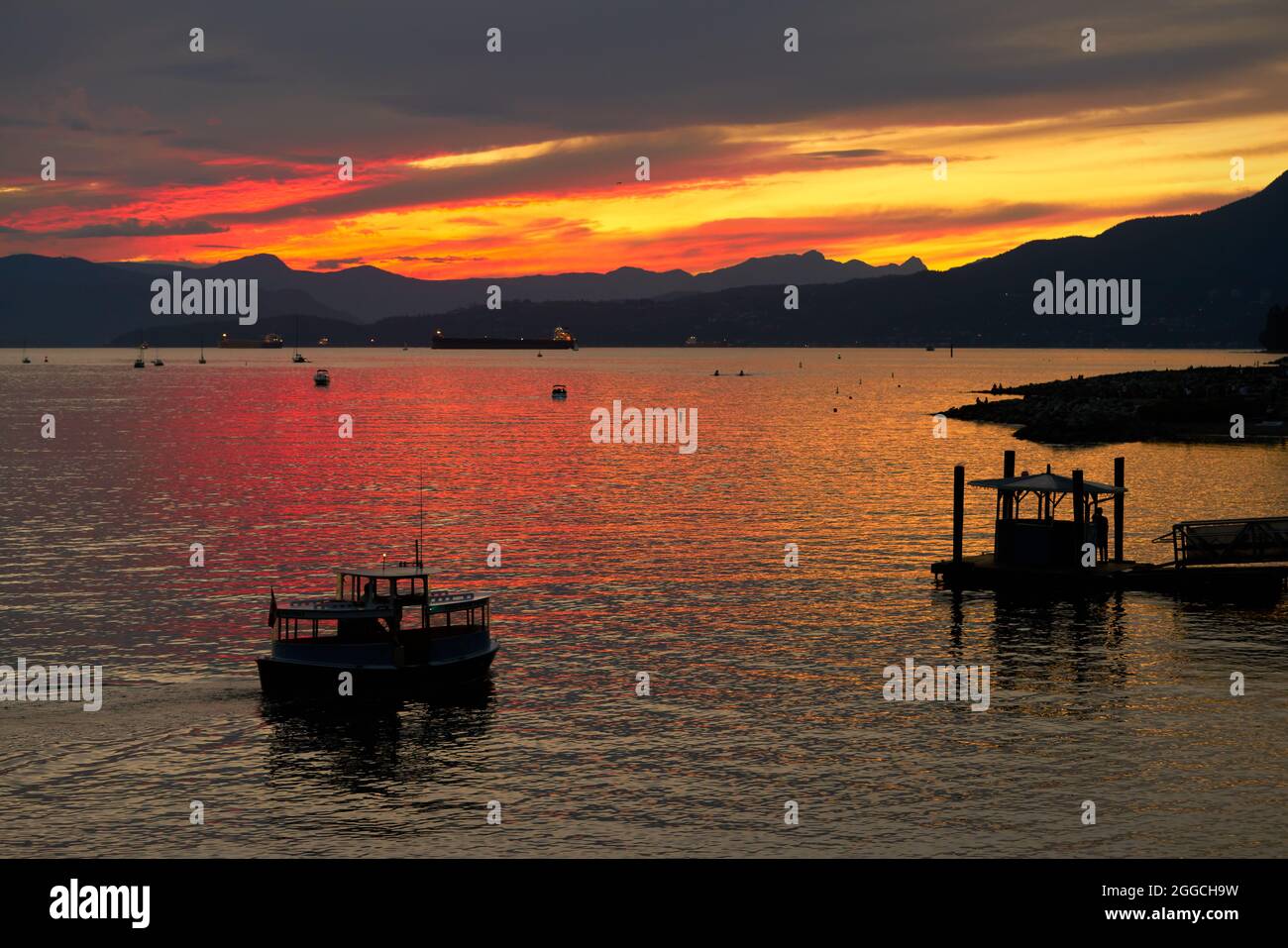 False Creek Ferry Sonnenuntergang Vancouver. Sonnenuntergang an der English Bay. Eine Pendlerfähre fährt zum Dock. Vancouver, British Columbia, Kanada. Stockfoto
