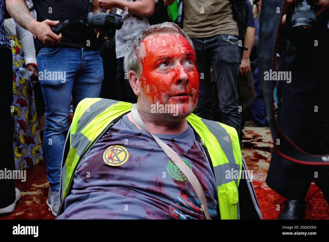 London, Großbritannien. Ein Protestler der Rebellion des Aussterbens, der an dem „Blutgeld“-marsch der Gruppe teilnimmt, sitzt mit gefälschtem Blut auf seinem Gesicht Stockfoto