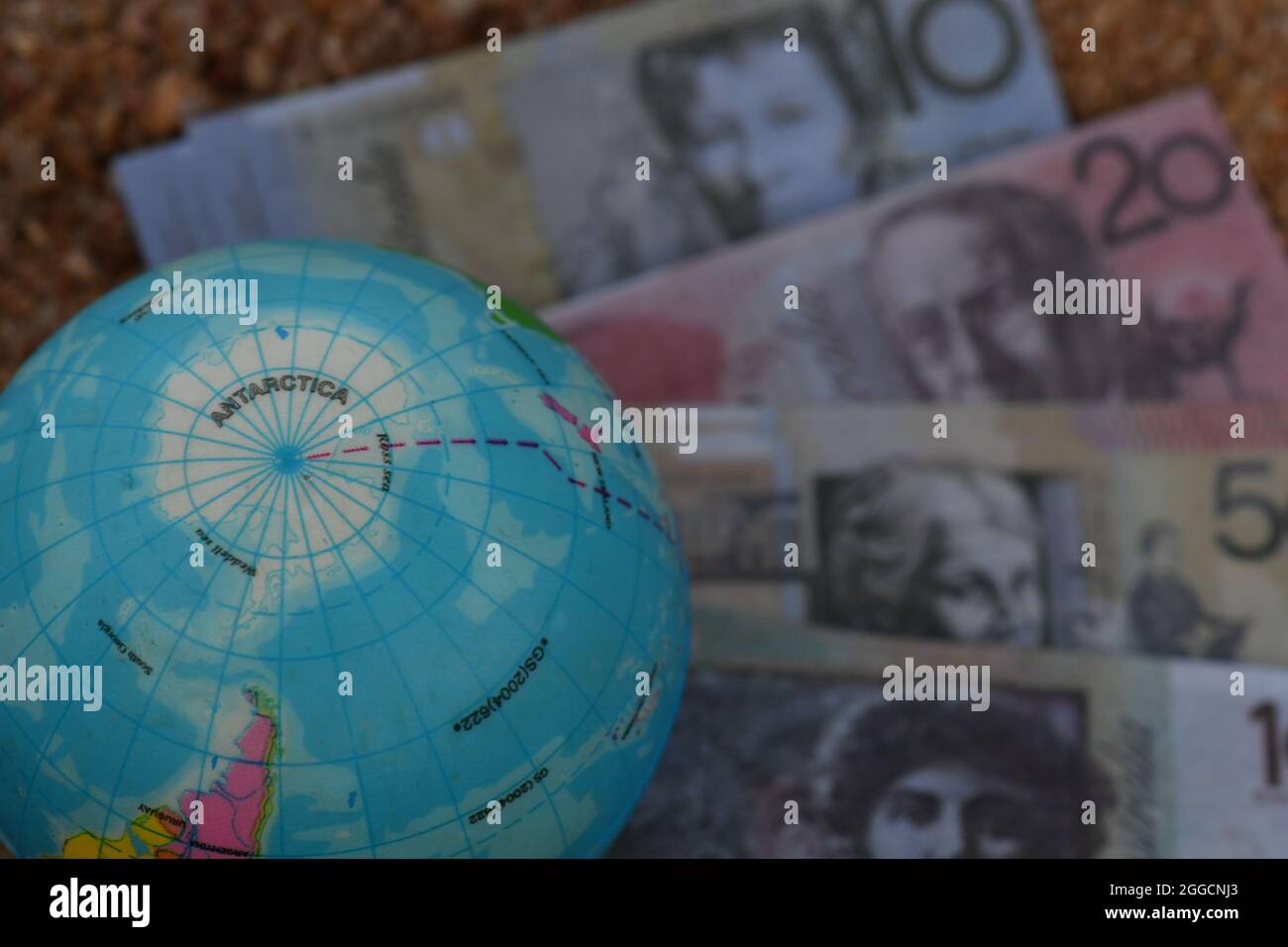Erdglobenkarte der Antarktis, die in der Natur auf einer Gruppe von Banknoten sitzt. Stockfoto