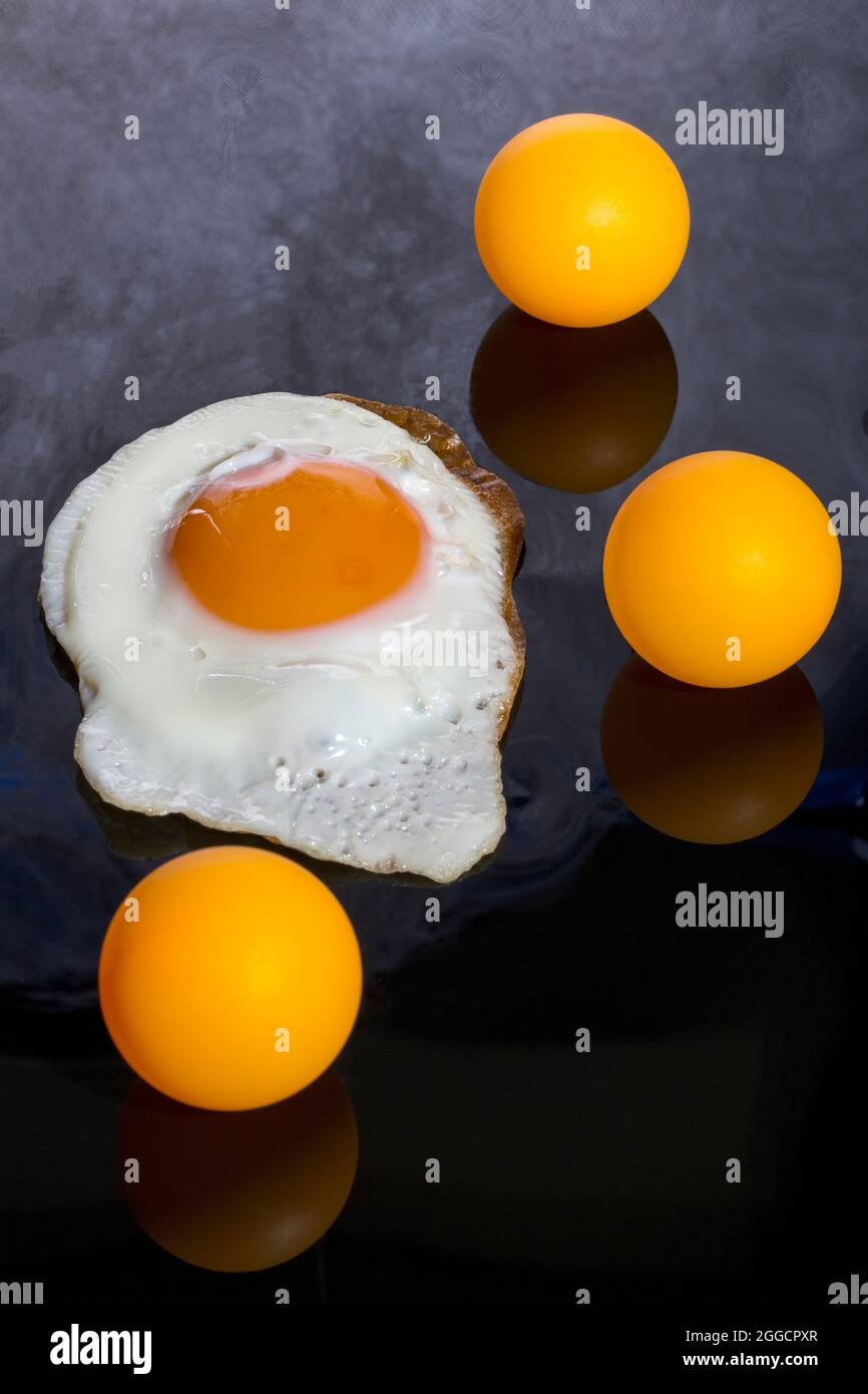 Stillleben mit gerösteten Rühreiern und Orangenbällen auf abstraktem Hintergrund Stockfoto