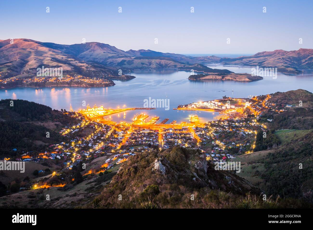 Lichter von Lyttelton und Diamond Harbour bei Sonnenaufgang, Lyttelton Harbour, Banks Peninsula, Canterbury Stockfoto