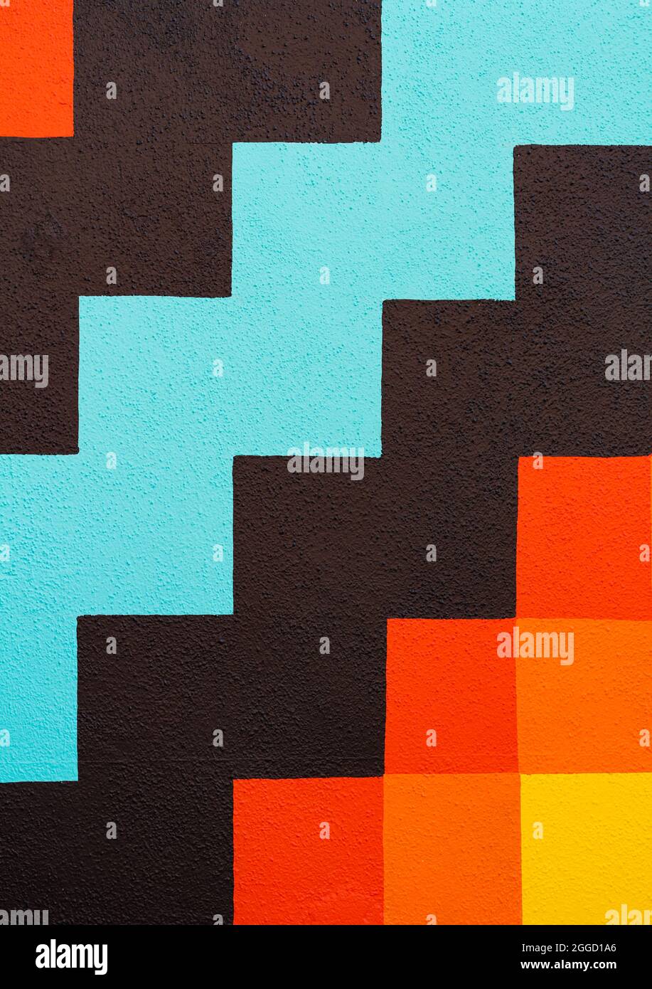 Abstraktes buntes geometrisches Muster auf einer Betonwand eines Hauses. Straßenansicht, Reisefoto, selektiver Fokus, Konzeptfoto abstrakte Hintergründe Stockfoto