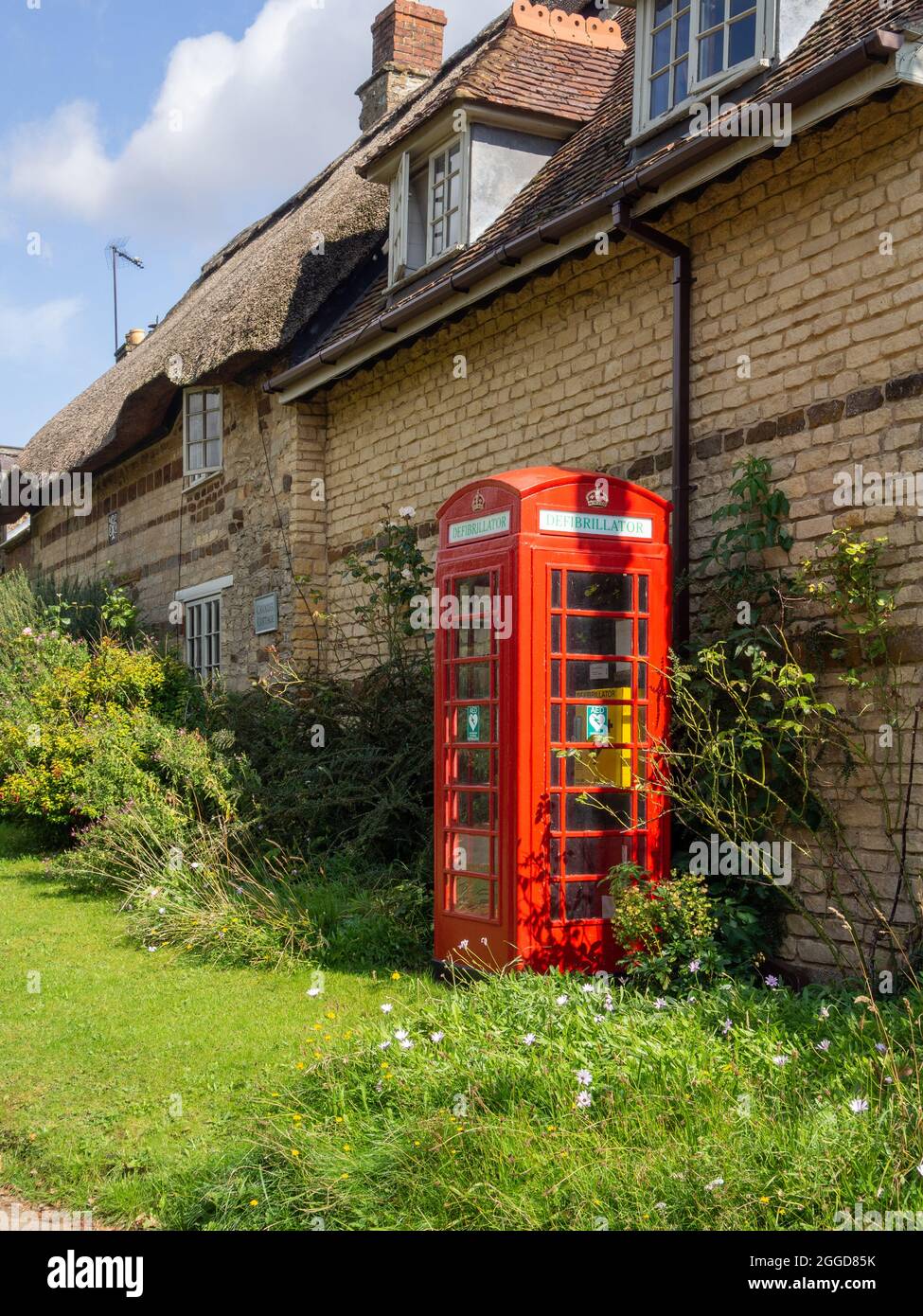 Ein alter roter Telefonkioské im Dorf Upper Stowe Northamptonshire, der jetzt als Defibrillator-Einheit genutzt wird, gehört zum BT und verabschiedet EIN Kiosk-System. Stockfoto