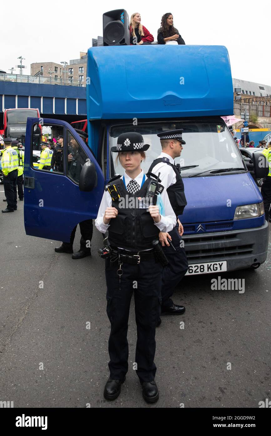 London, Großbritannien. 30. August 2021. Umweltaktivisten von Extinction Rebellion sperren während einer „Impossible Tea Party“-Veranstaltung die Mansell Street nördlich der Tower Bridge in einem blauen Van ein. Extinction Rebellion lenkte die Aufmerksamkeit auf Finanzinstitute, die Projekte für fossile Brennstoffe finanzieren, und forderte die britische Regierung auf, alle neuen Investitionen in fossile Brennstoffe mit sofortiger Wirkung am achten Tag ihrer Impossible Rebellion-Proteste in London einzustellen. Kredit: Mark Kerrison/Alamy Live Nachrichten Stockfoto