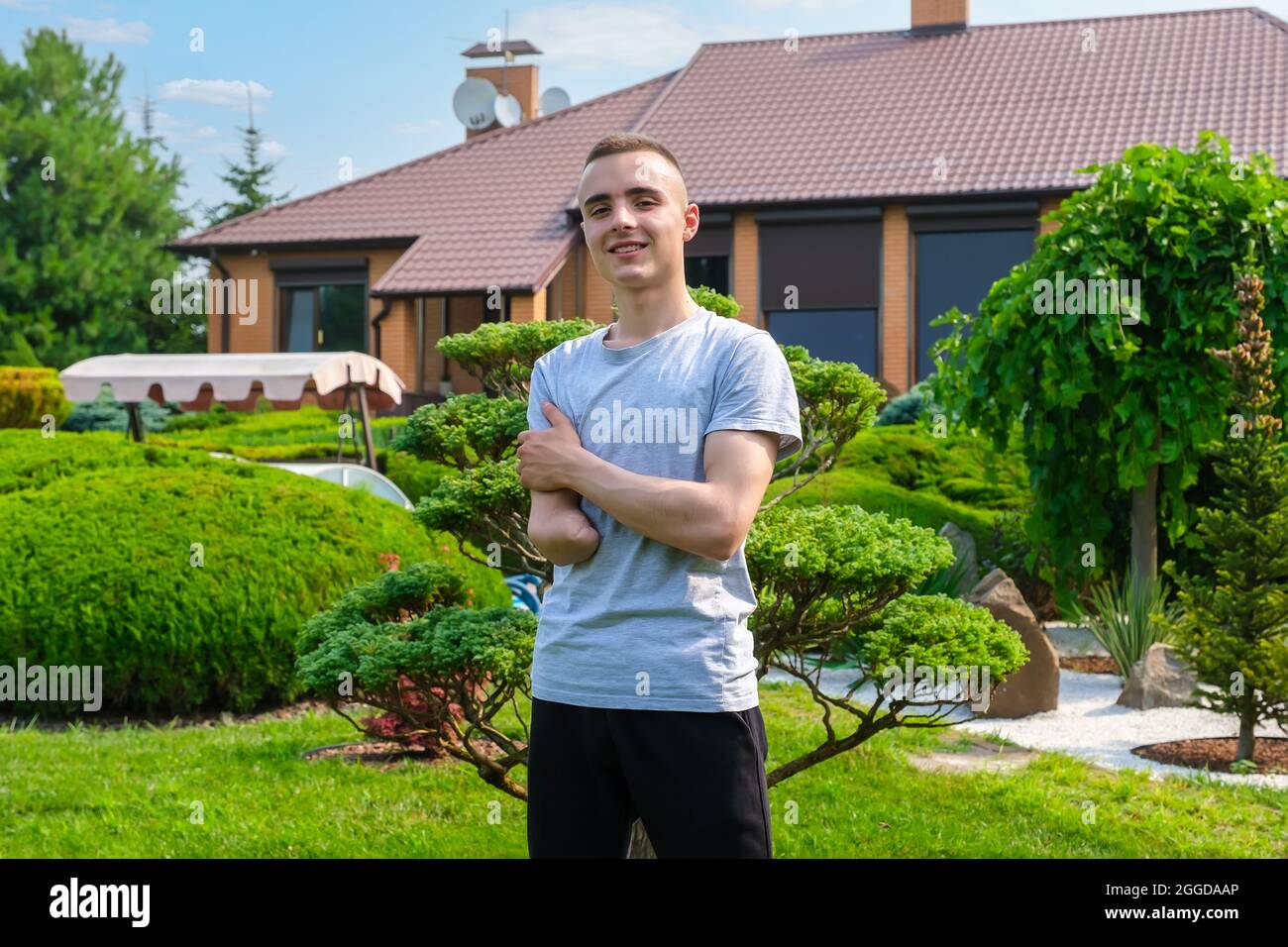 Junger positiver Mann mit Behinderung posiert im Freien Stockfoto