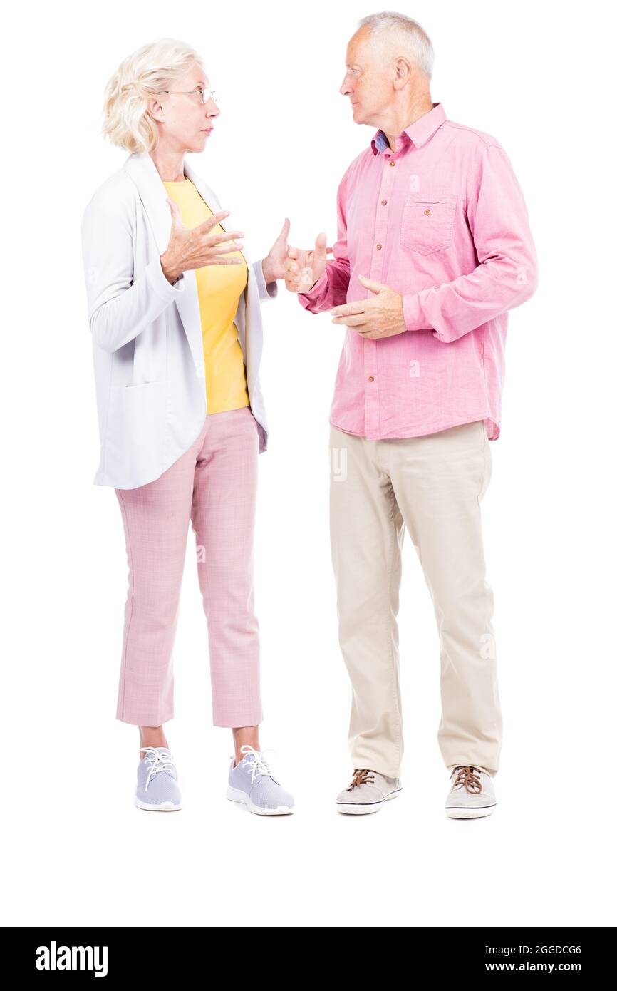 Vertikale Ganzkörperaufnahme von älteren Männern und Frauen, die miteinander stehen und über etwas reden, weißer Hintergrund Stockfoto