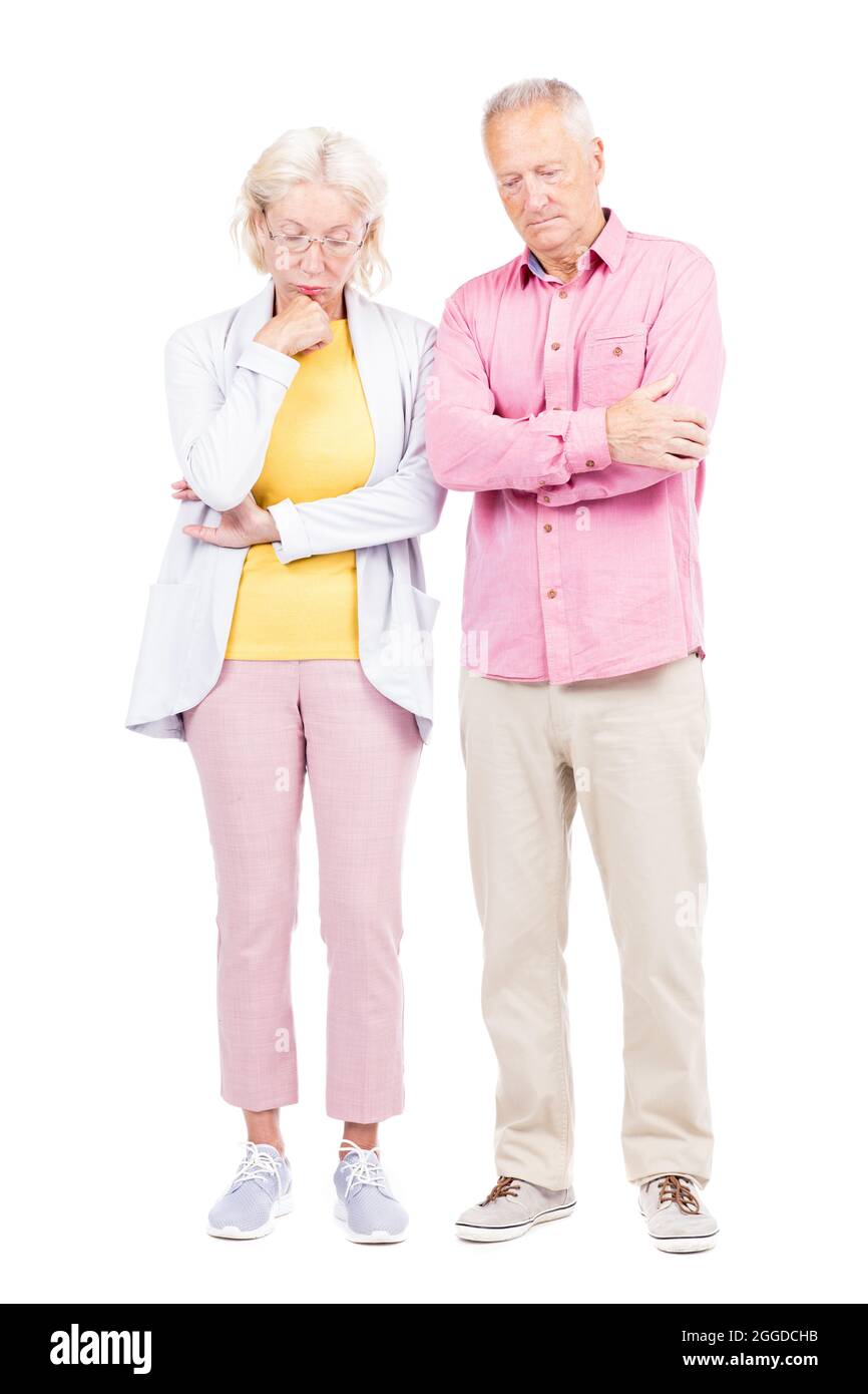 Vertikale Ganzkörperaufnahme von nachdenklichen älteren Mann und Frau, die zusammen an etwas denken, weißer Hintergrund Stockfoto