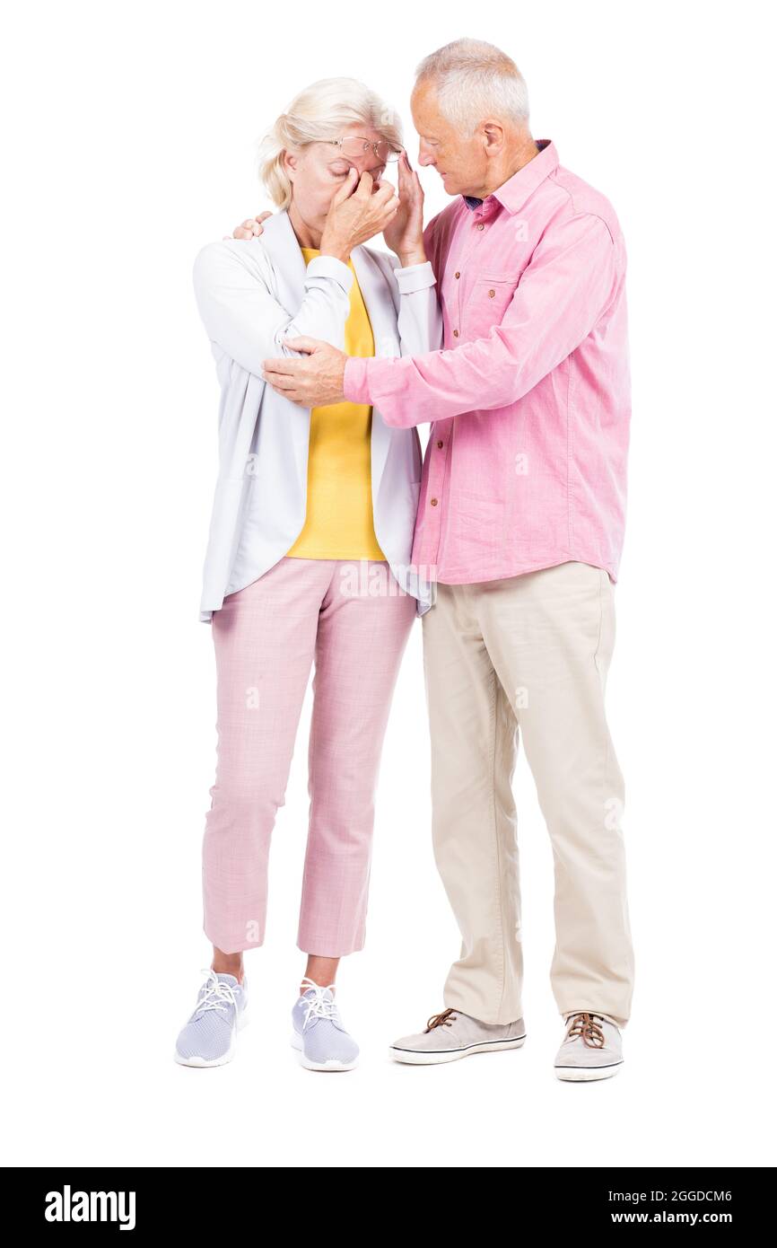 Vertikale Ganzkörperaufnahme von liebenden älteren Mann tröstet seine Frau, während sie weint, weißer Hintergrund Stockfoto