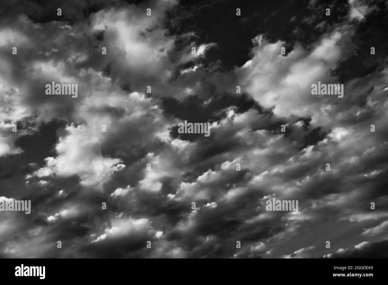 Flauschige Wolken am blauen Himmel mit Kopierraum, monochrom Stockfoto
