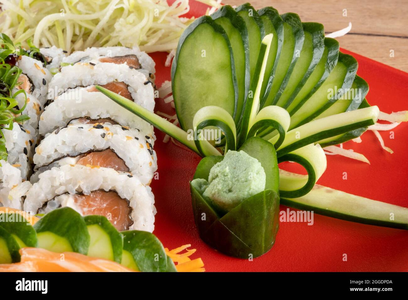 Gemischte Sushi-Rolle und Lachs-Sashimi auf rotem Teller. Stockfoto